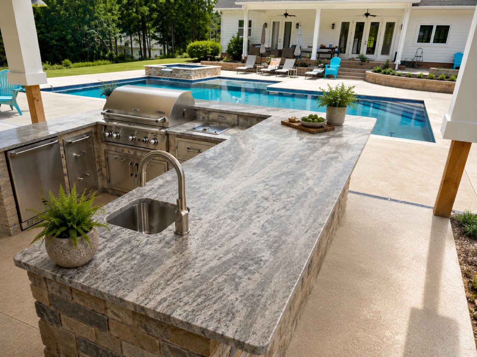 Outdoor stone kitchen beside a pool